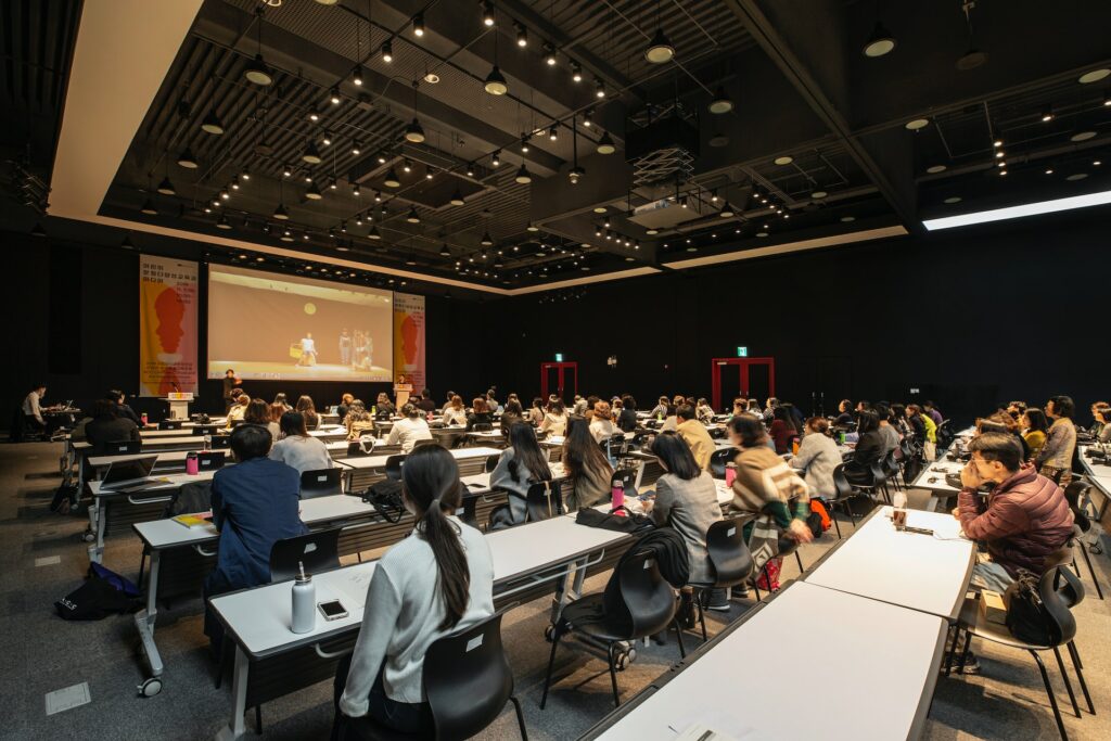 invest in eLearning - photo of an audience in an auditorium looking at the presentation in front of them